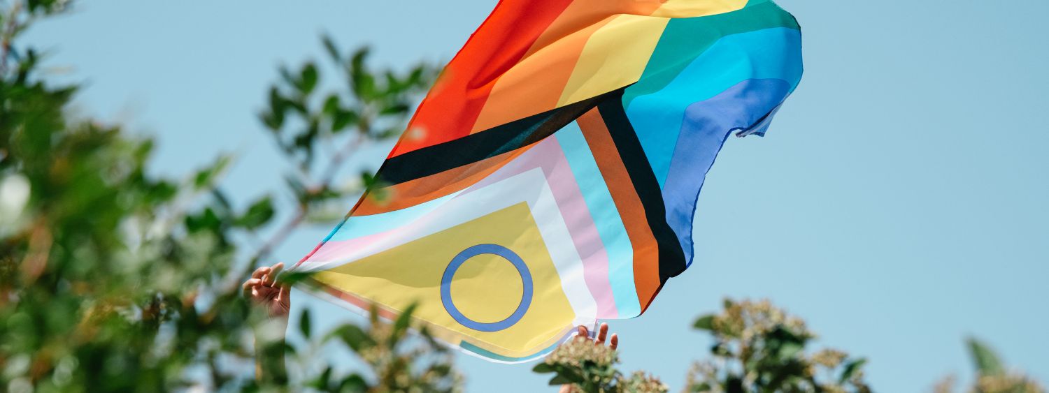 A Pride flag flies high in the sky