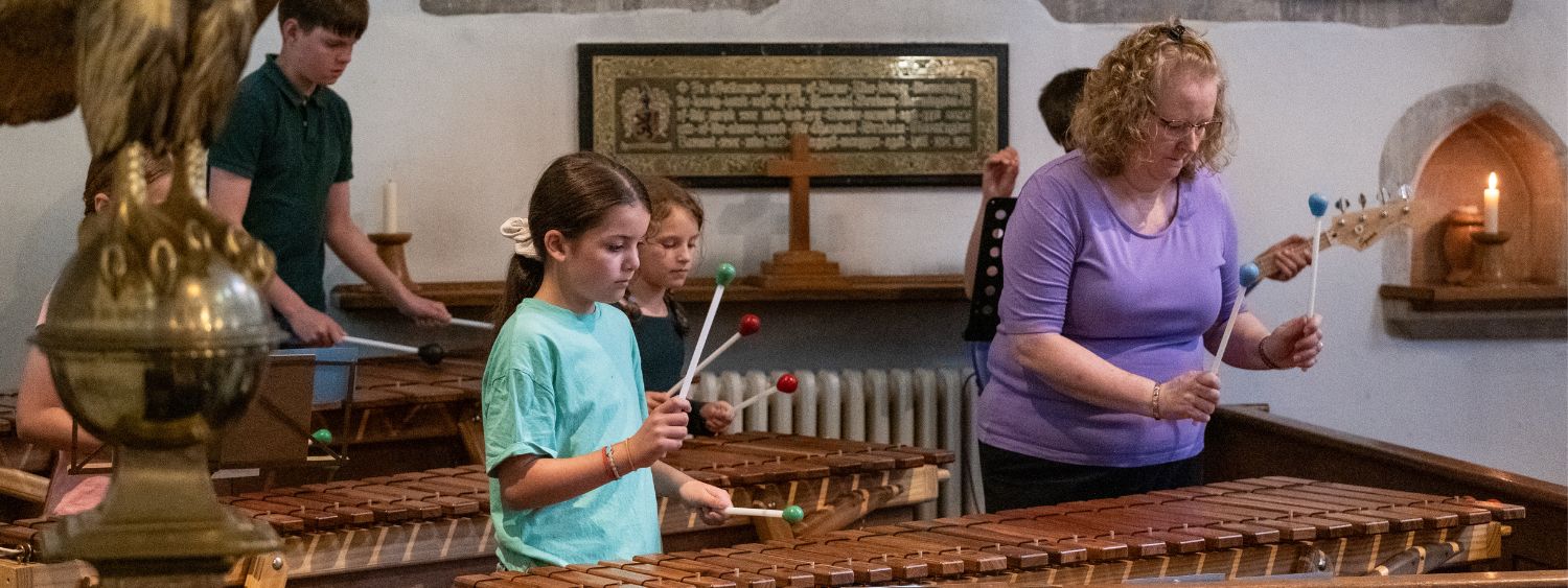 Children play the marimba to welcome people to their church