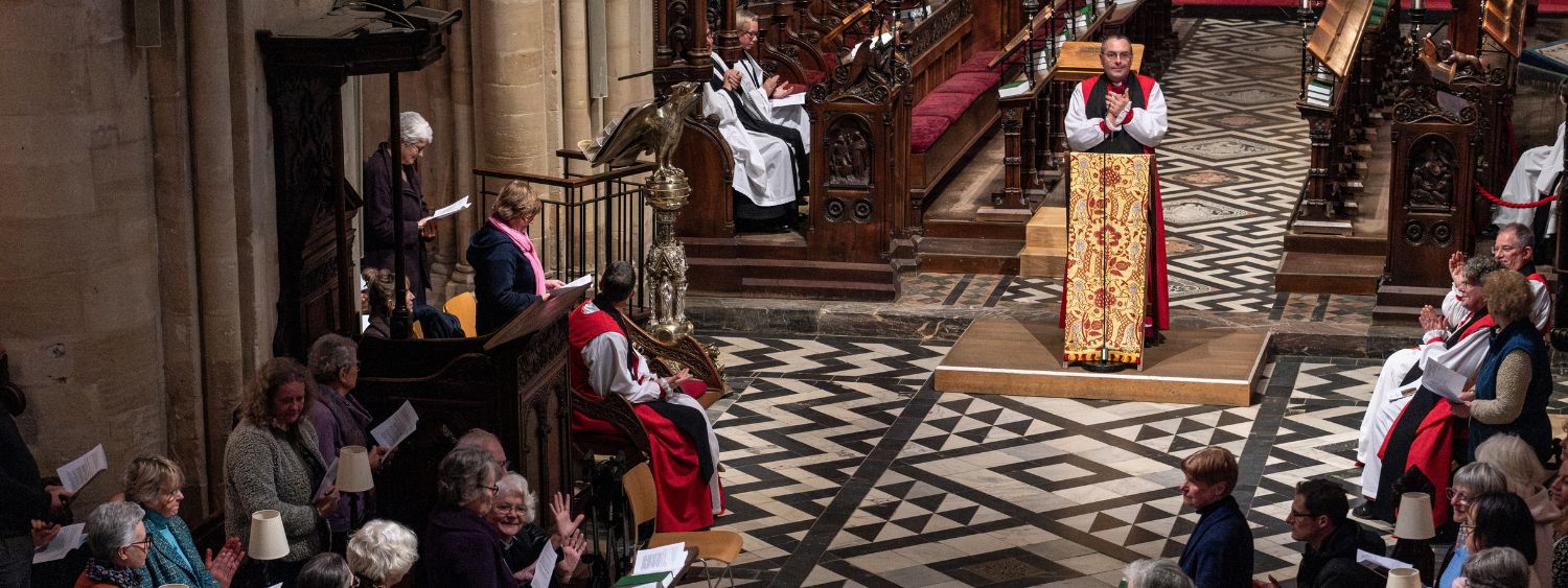 Bishop Gavin leads the Cathedral congregation in applause for Parish Safeguarding Officers, who stand in their pews