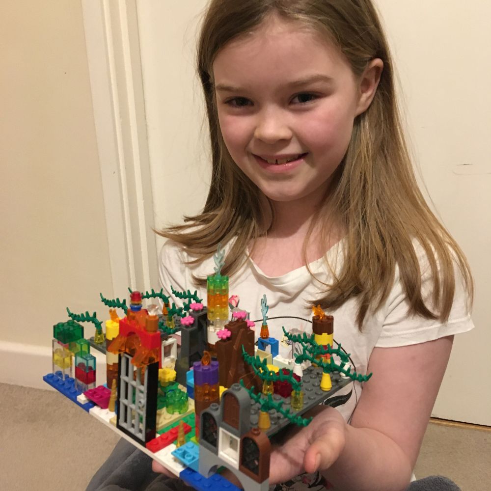 Eleanor holds an Advent wreath made out of Lego.