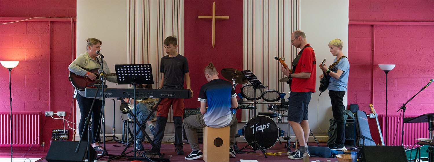 A group of young people practice as part of a worship band
