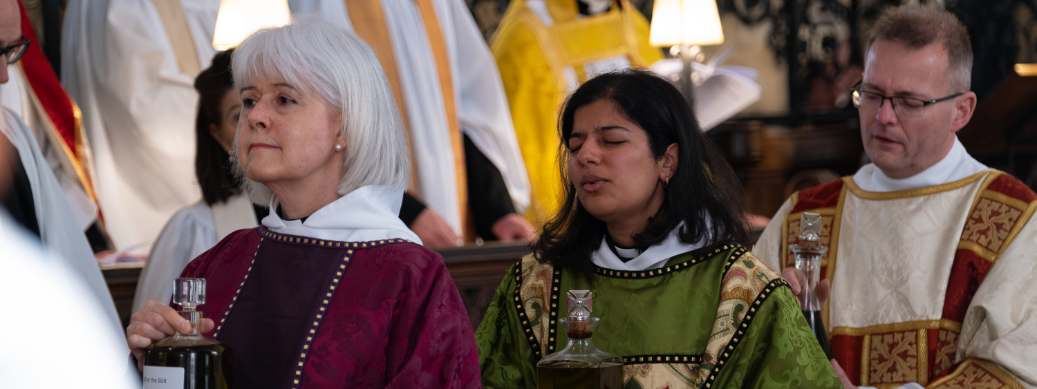 A deacon holds a bottle of Chrism Oil above their head in procession at Chrism Mass at Christ Church Cathedral Oxford