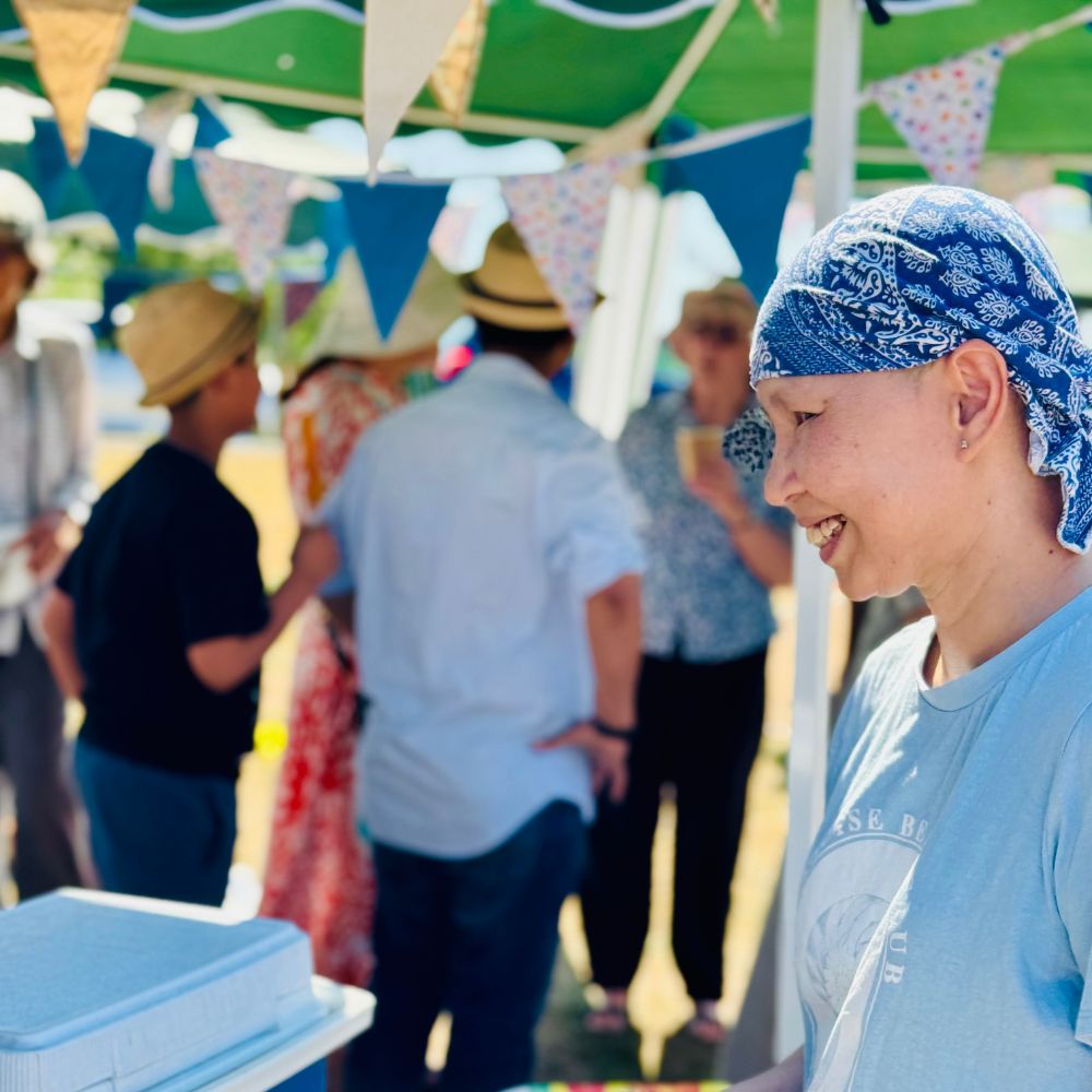 A customer at rhe Abbey Fields welcome event smiles with bunting and other guests behind her