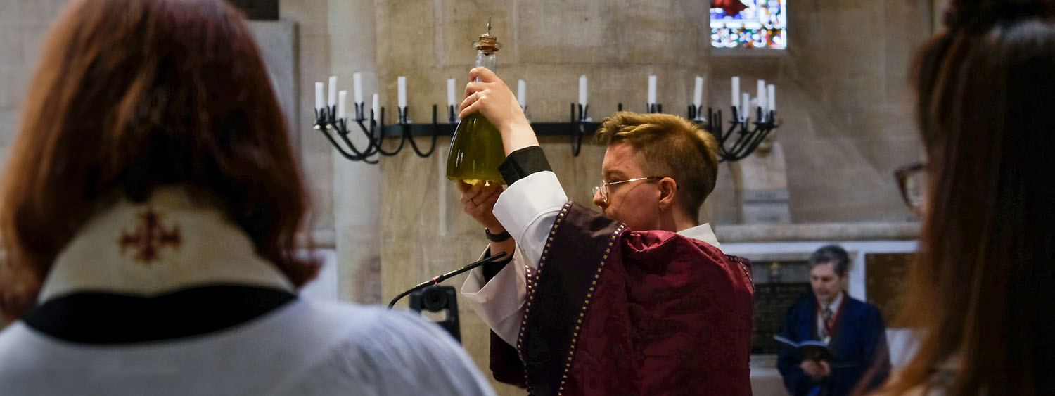 A deacon holds a bottle of Chrism Oil above their head in procession at Chrism Mass at Christ Church Cathedral Oxford