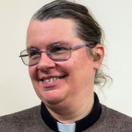 The Revd Dr Hannah Lewis smiling and looking to the left