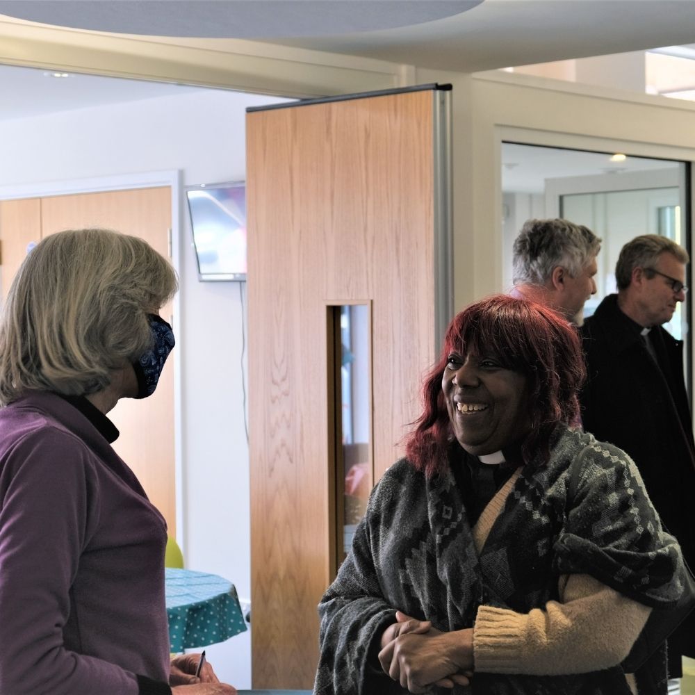 The Revd Polly Falconer is smiling whilst talking to a lady wearing a facemask in Didcot Baptist Church.