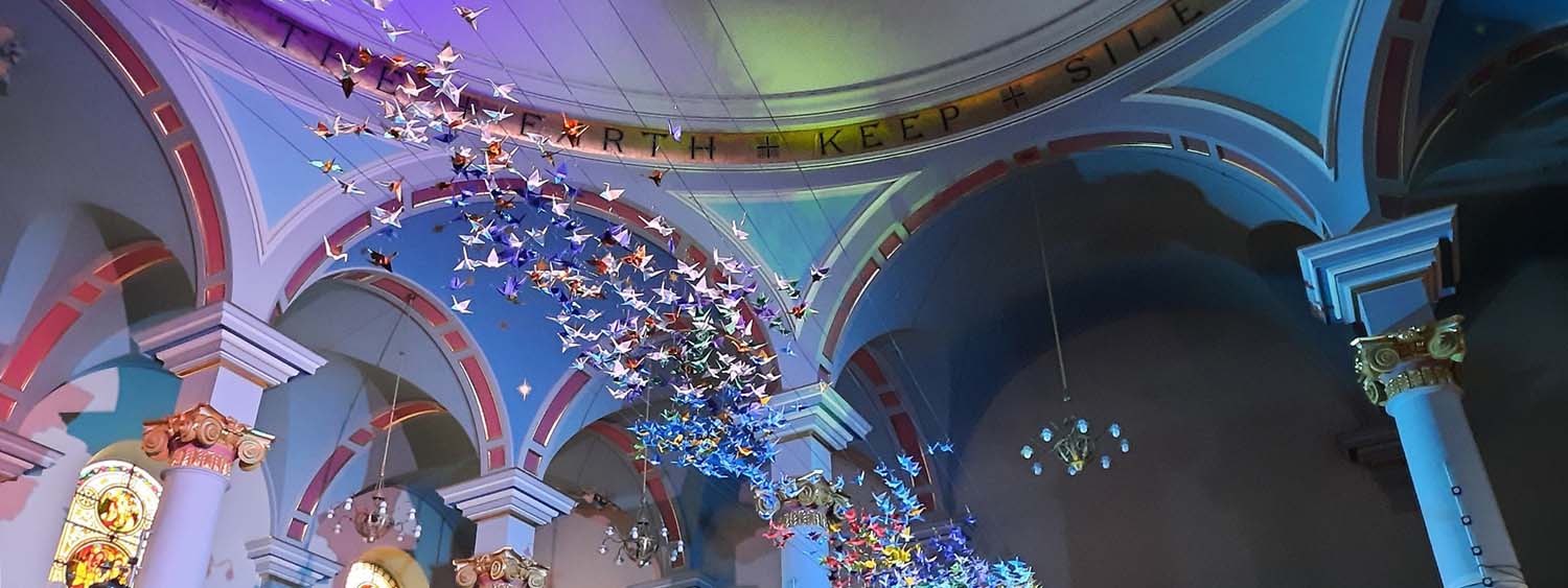 Hundreds of origami cranes hang from St Mary's, Banbury, as part of their arts festival. The cranes are lit in vibrant colours