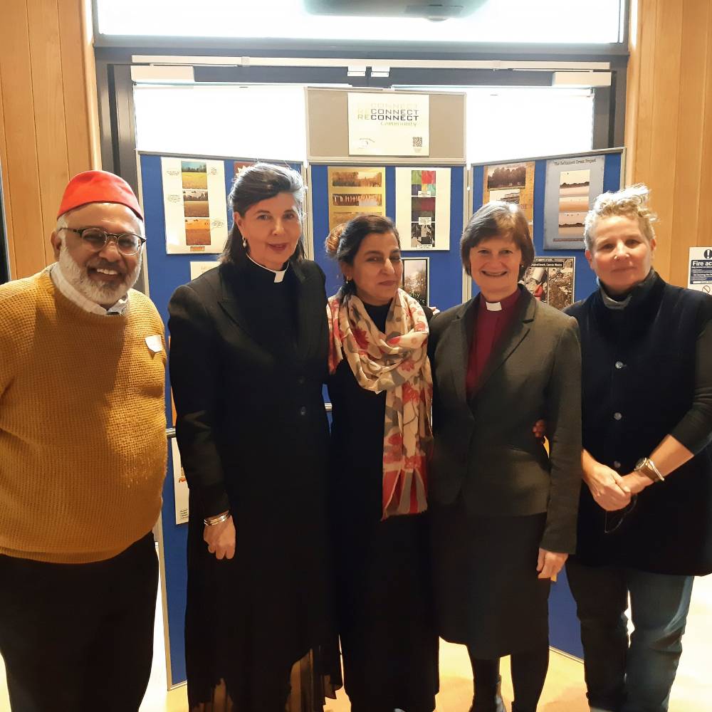 Five event speakers, from different faiths, stand together smiling including the Bishop of Reading and Imam Monawar Hussein