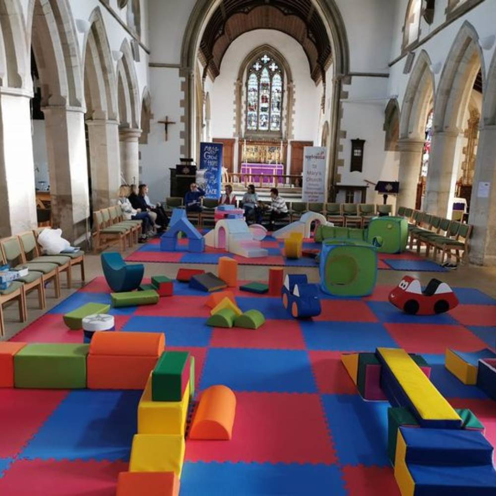 Inside of St Mary's Church, the floor is laid with multi coluored soft play mats and soft play equipment