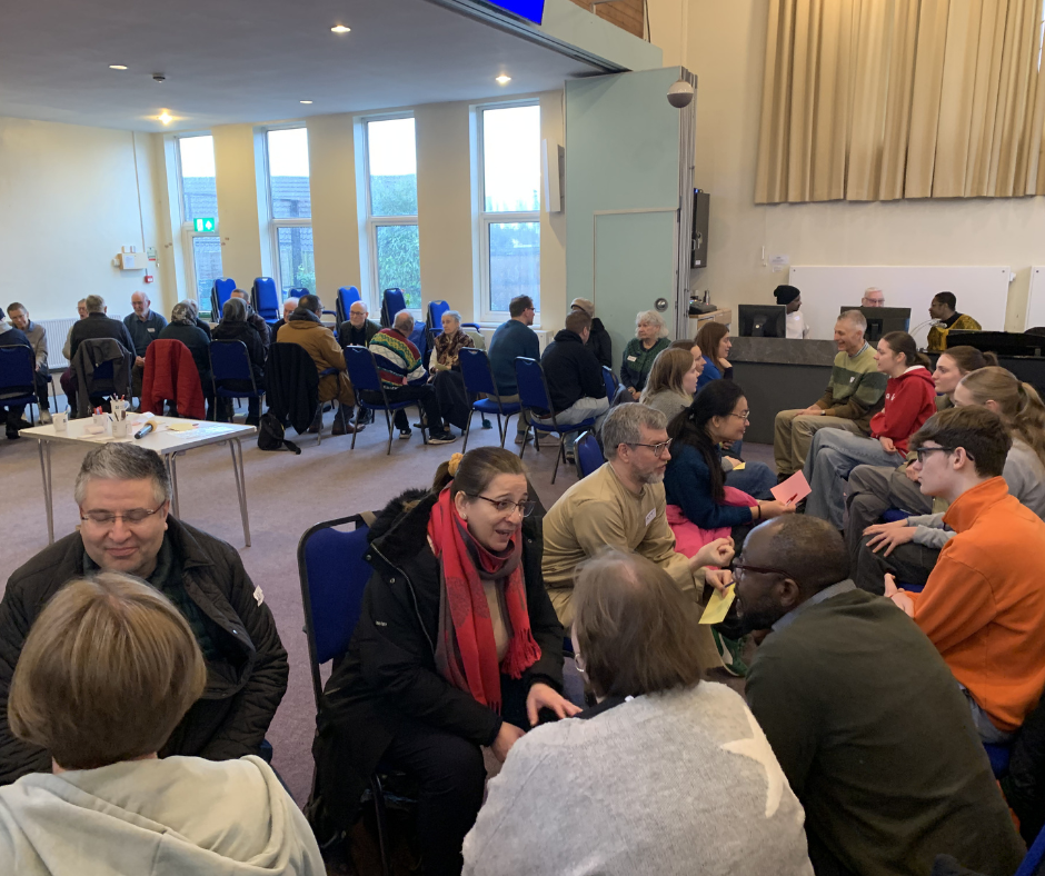Photo of a large room with many people talking